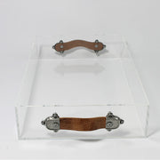 A small clear acrylic tray with brown leather handles, positioned on a white background.
