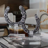 Decorative black and white beaded headpiece on a clear stand with a blurred indoor background