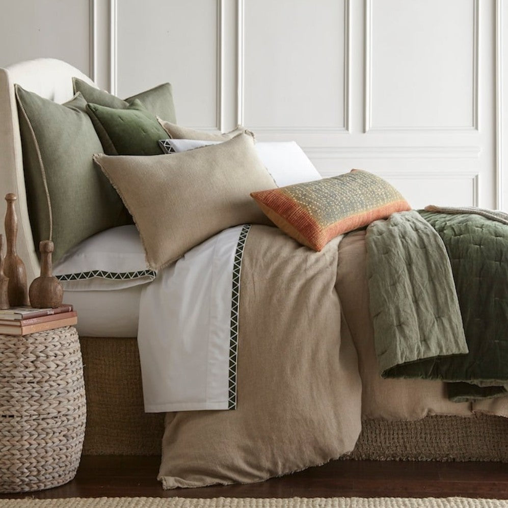 Neatly made bed with pillows and a blanket in a bedroom setting