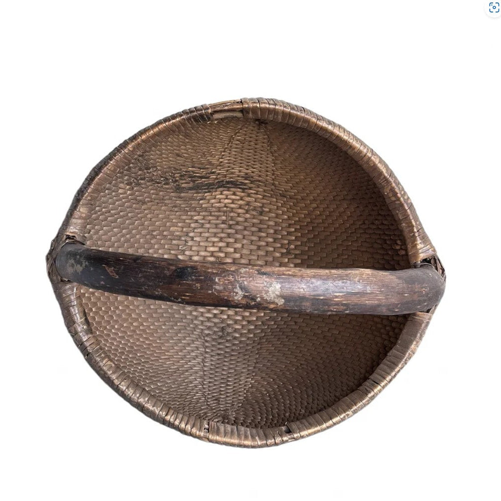 Woven basket with a handle on a white background