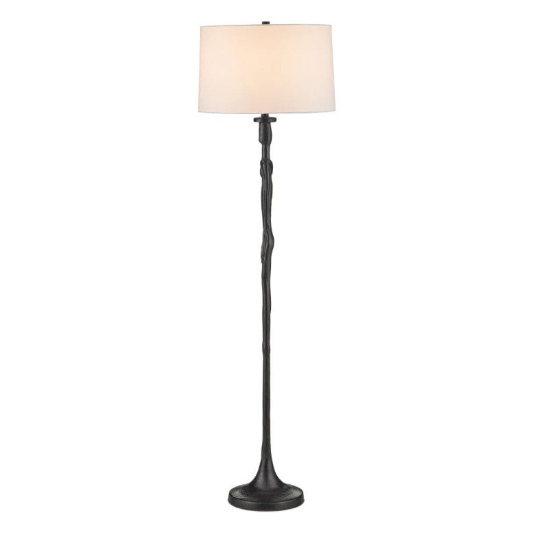 A tall floor lamp with a dark, textured, branch-like metal base and a cylindrical off-white fabric drum shade, shown against a plain white background.