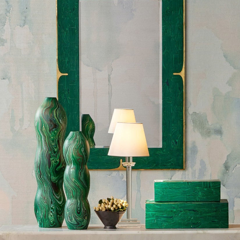 Two seed-pod shaped decorative vases with surfaces covered in marbling on a table with a lamp and matching boxes.