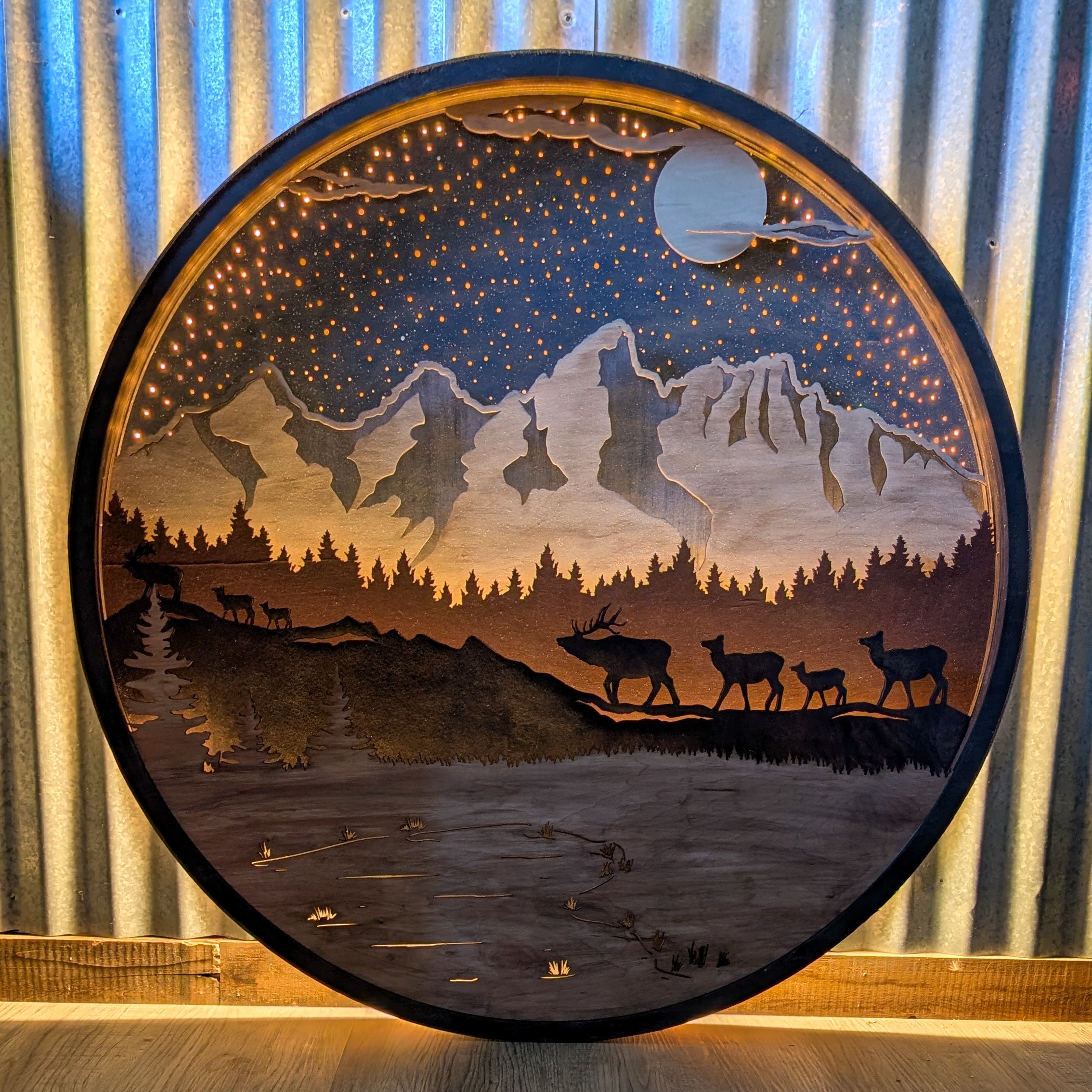 Wooden wall art with mountain and deer design against a striped curtain background