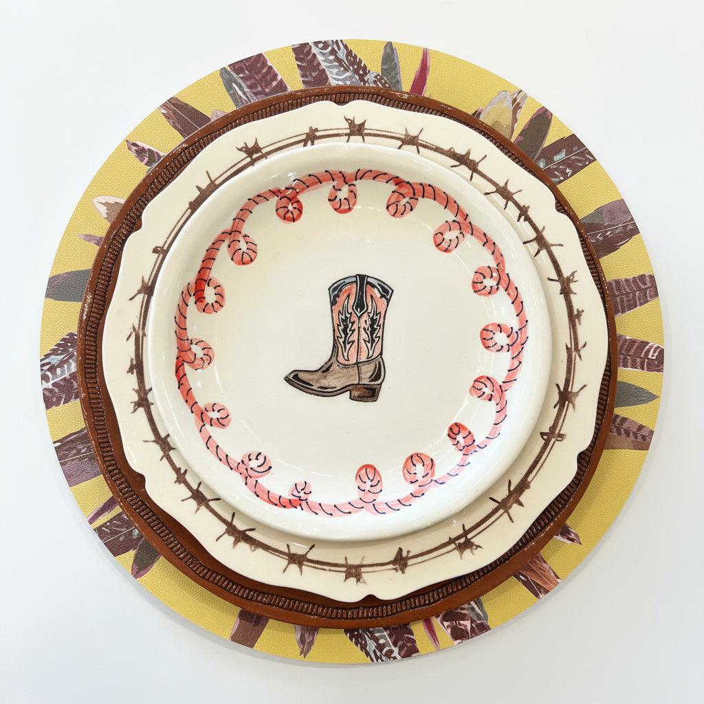 Decorative plate with cowboy boot and barbed wire design on a colorful rim.