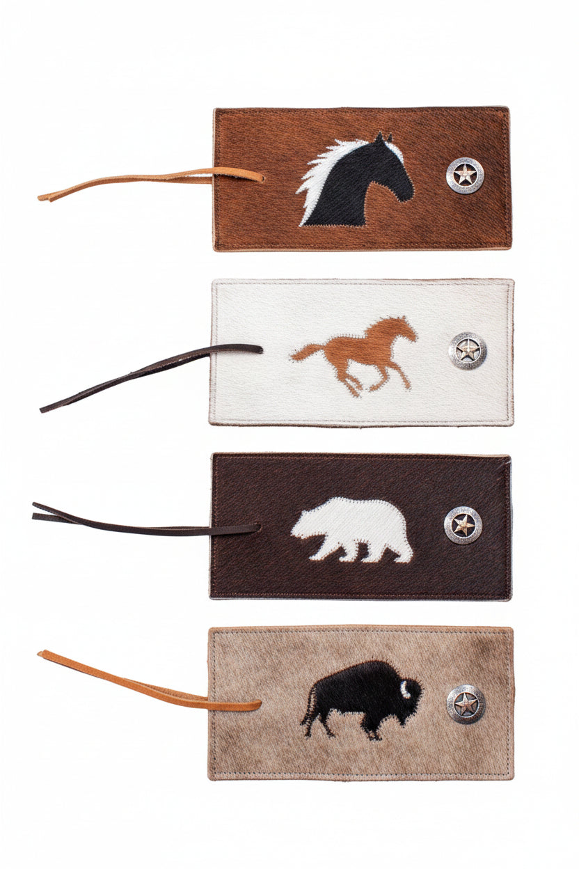 Set of four leather tags with animal illustrations on a textured surface