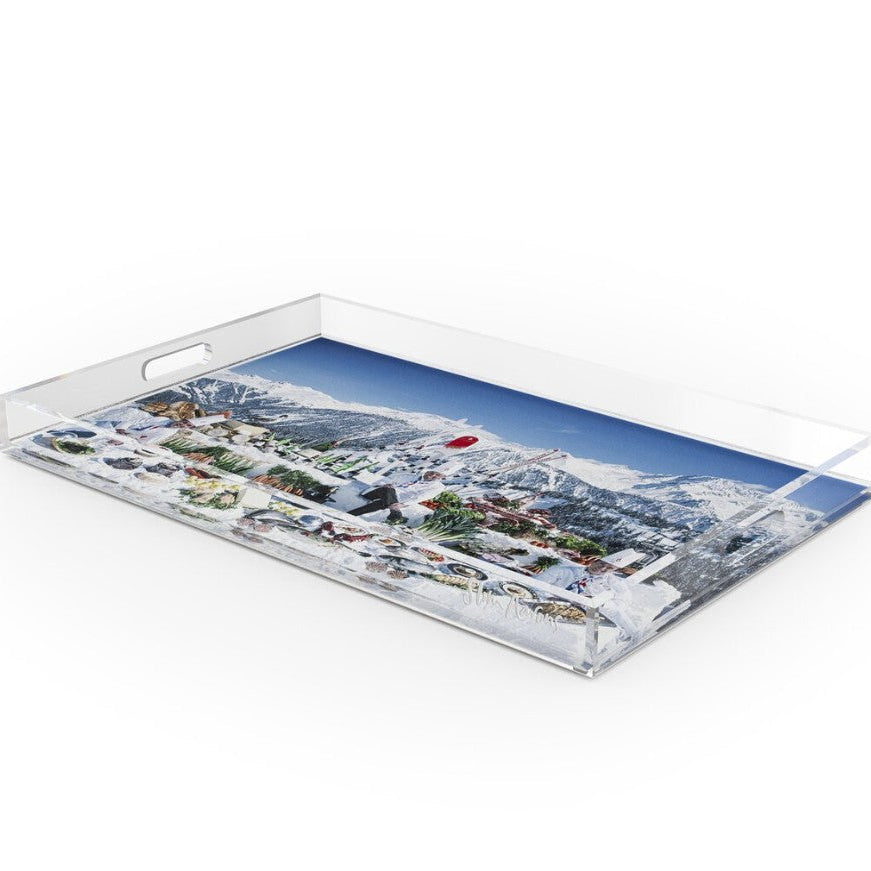 A clear acrylic serving tray with integrated handles, featuring a printed scenic image of a snowy mountain village under a blue sky on the tray surface.