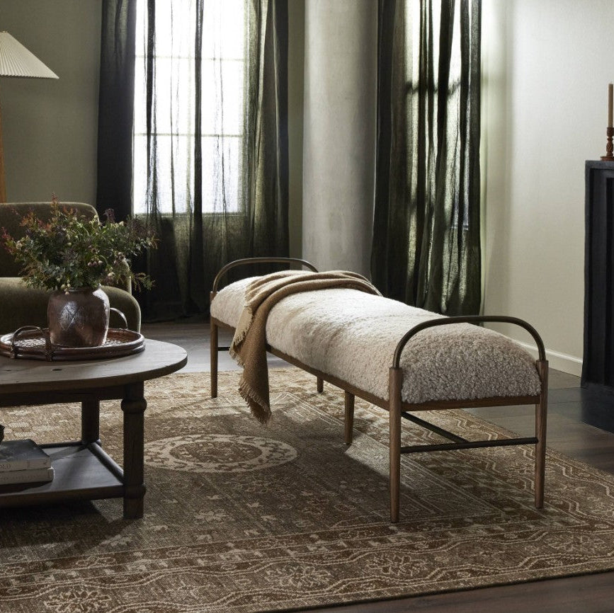 Living room with a bench, coffee table, and decorative items.