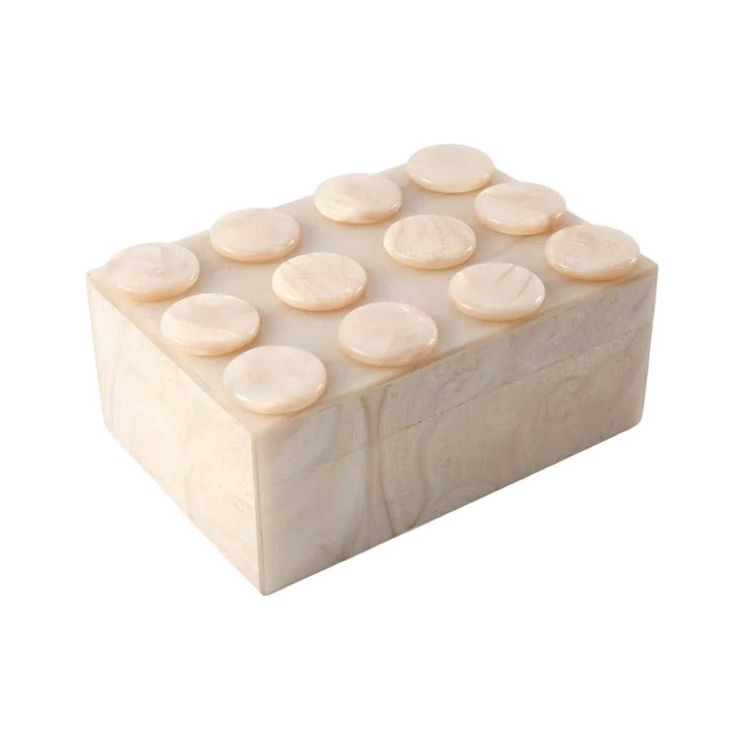 A rectangular cream-colored stone or bone box with a raised circular stud design on top, photographed on a plain white background.