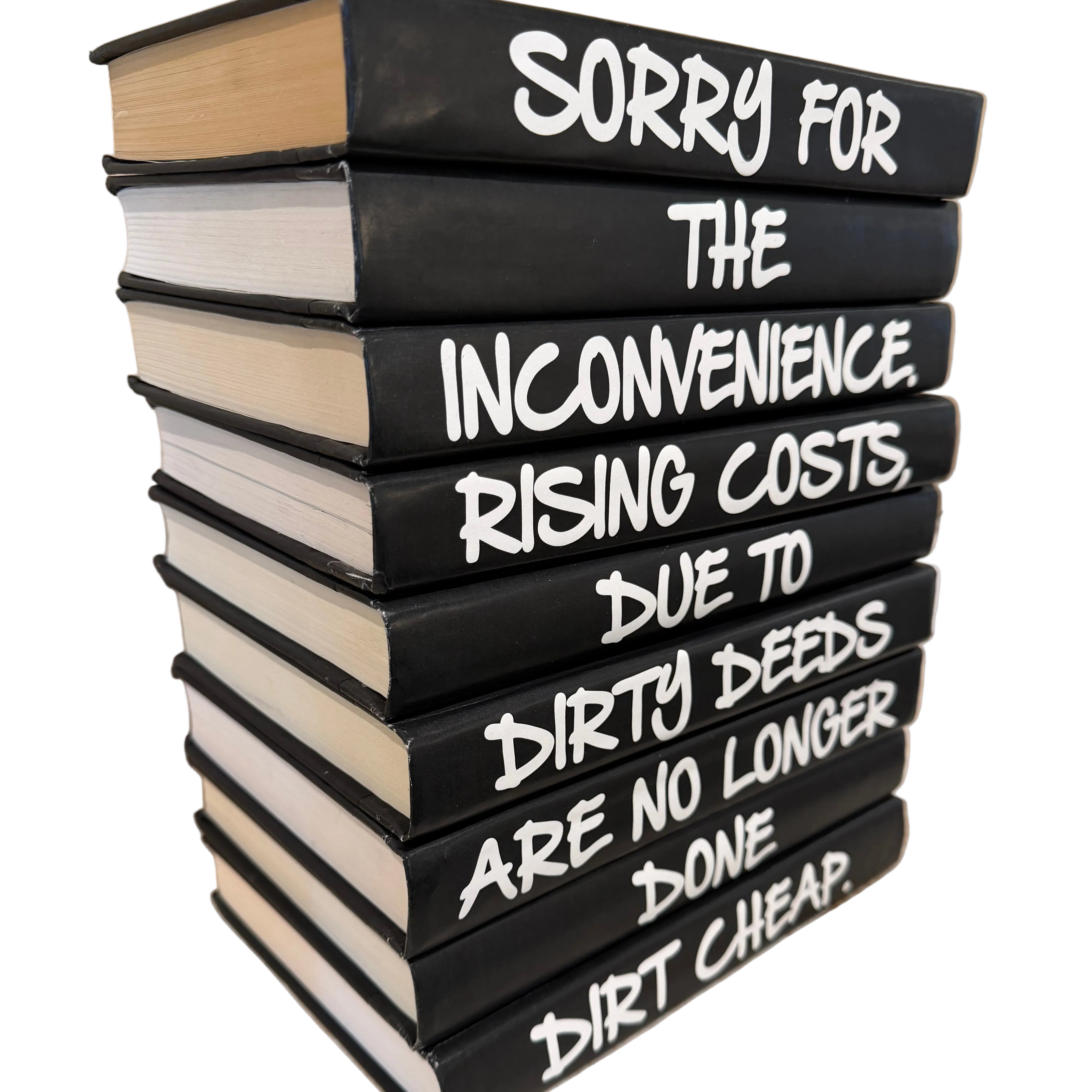 Stack of books with white text on black spines on a wooden surface.