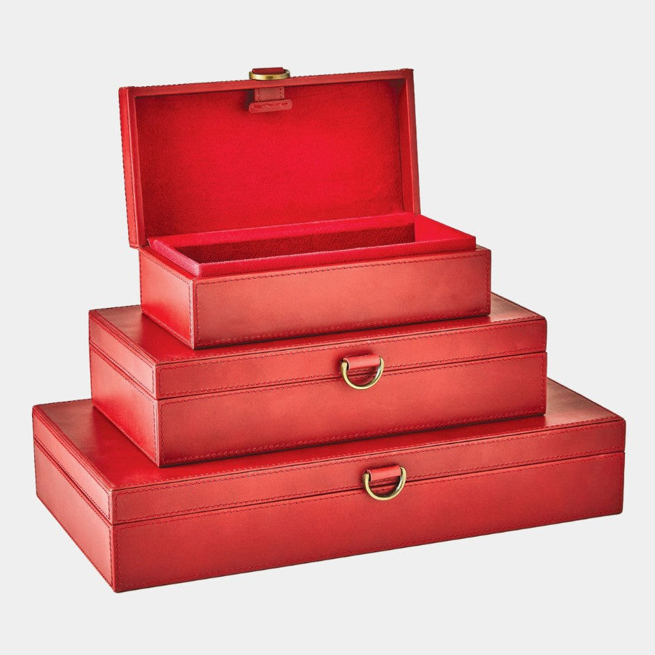Set of three red leather boxes with gold handles on a light gray background