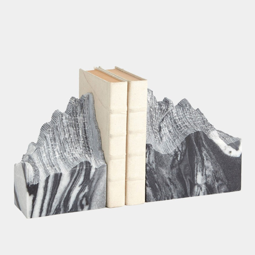 Bookends with mountain design holding books on a white background