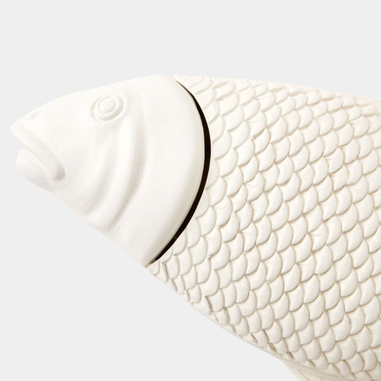 White ceramic fish-shaped object on a light gray background