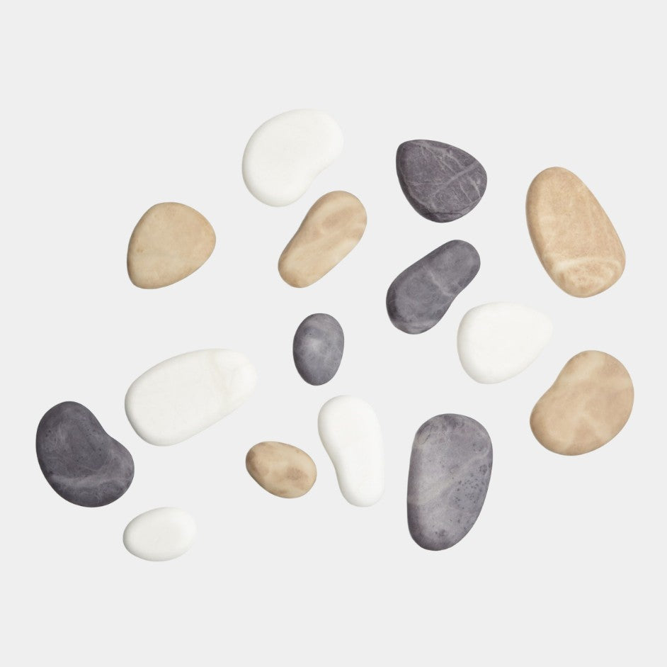 Assorted pebbles in various colors on a light gray background
