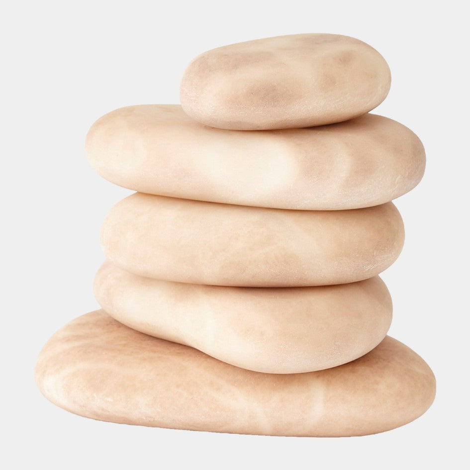 Stack of five beige stones on a light gray background