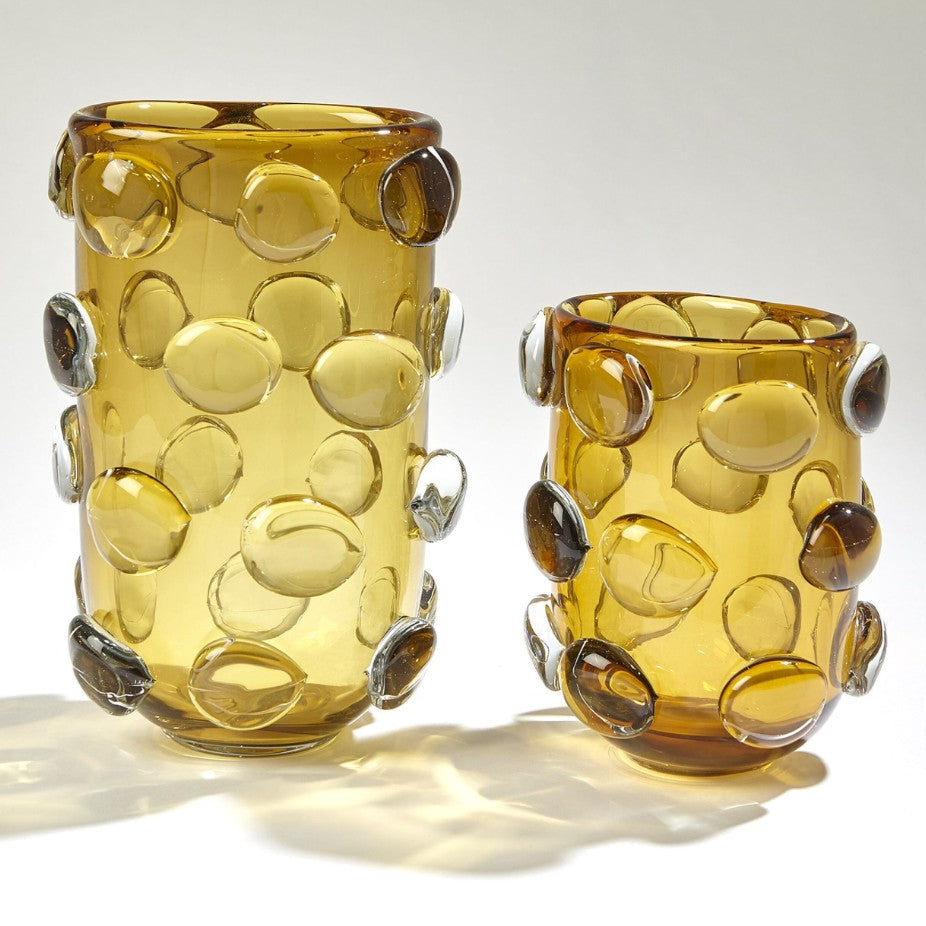 Two amber-colored glass vases with bubble-like designs on a white background