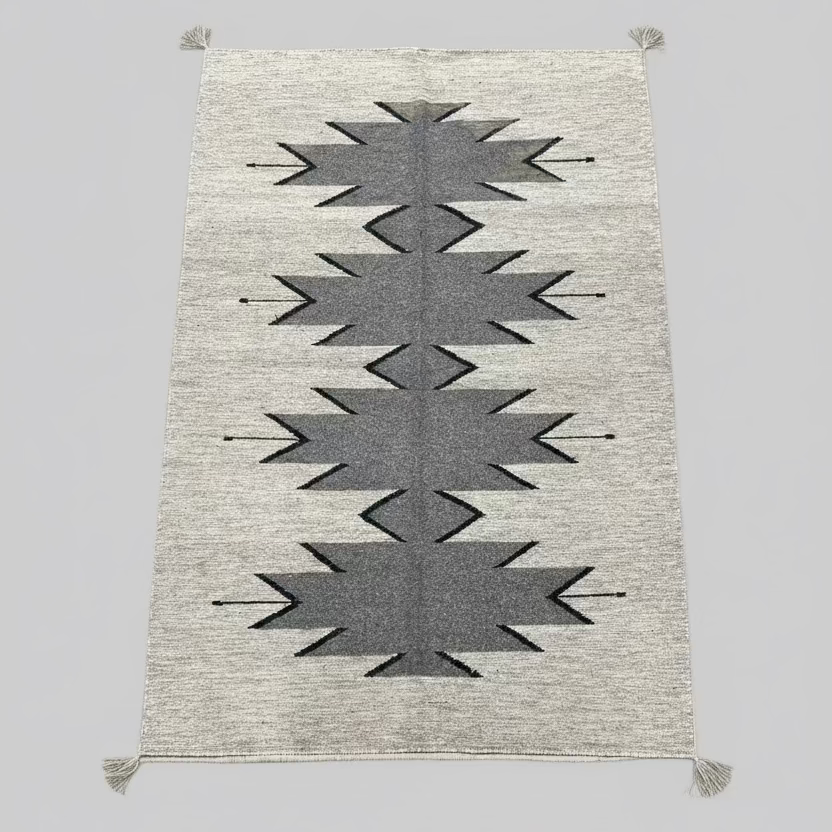 Gray and beige patterned rug on a plain background