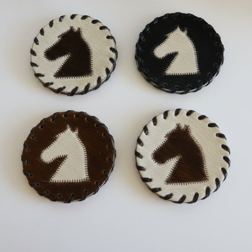 Four round embroidered patches with horse designs on a white surface.