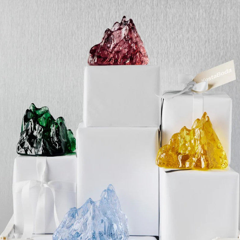Colorful crystal-like sculptures on a white surface with a gray background