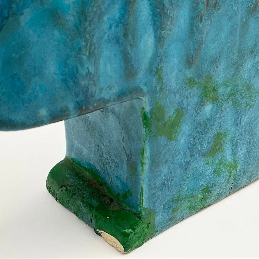 Close-up of a blue and green ceramic object on a white background
