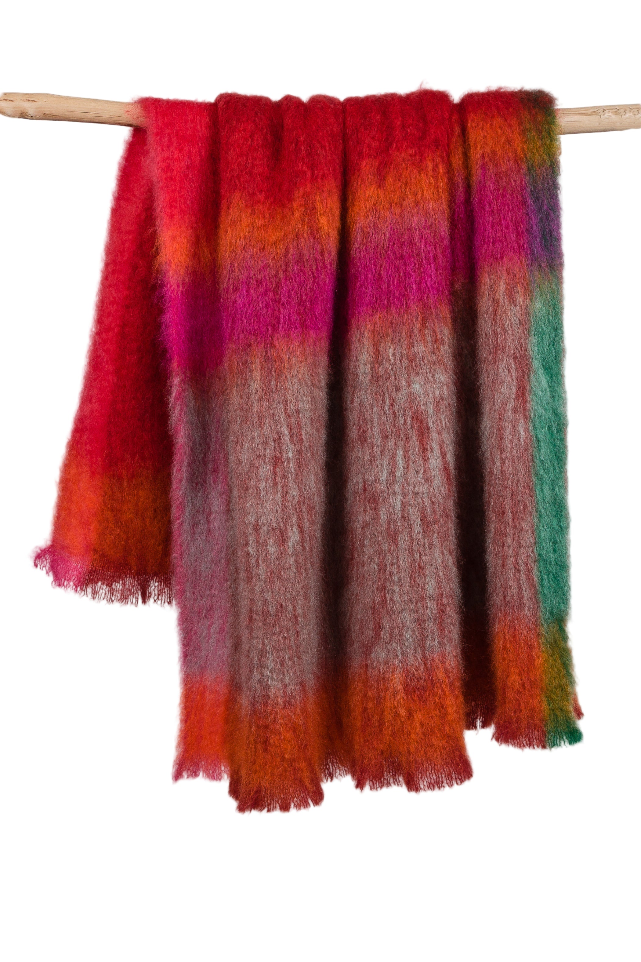 Multicolored scarf with gradient pattern draped over a wooden rod on a light gray background