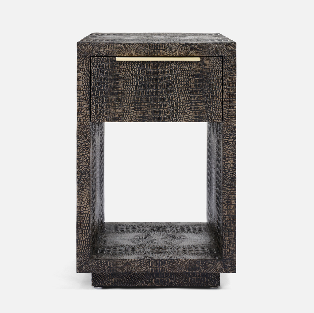 A dark brown textured side table with a single drawer featuring a brass pull handle, set against a plain light gray background.