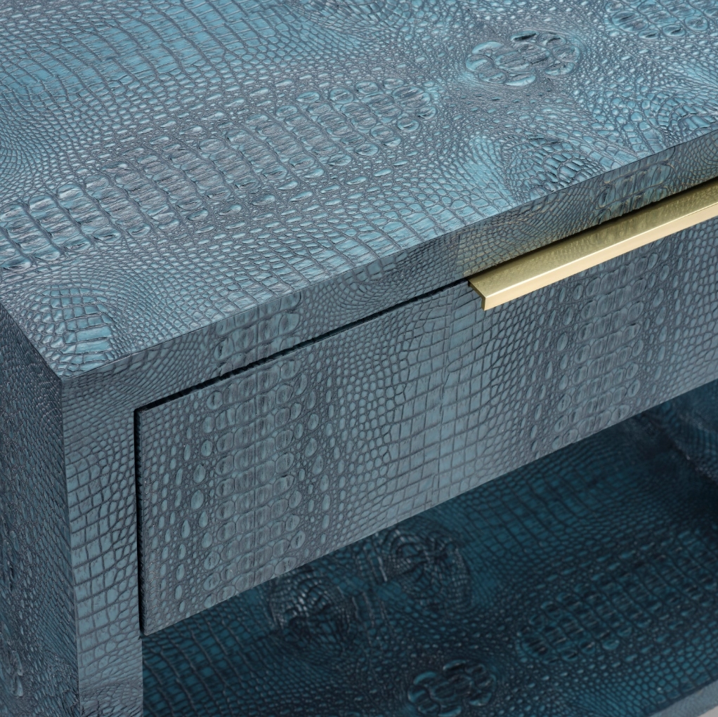Close-up of a luxury sideboard or drawer with a textured crocodile skin pattern in a teal-blue finish, featuring a brushed gold metal pull handle.