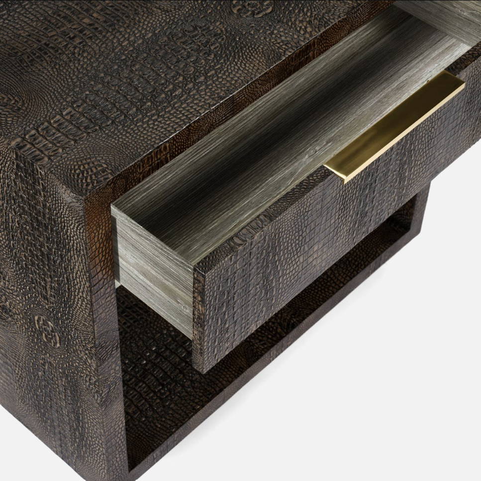 Close-up of a dark brown textured furniture piece with a pulled-out drawer showing a gray wood-grain interior and a brass pull handle.