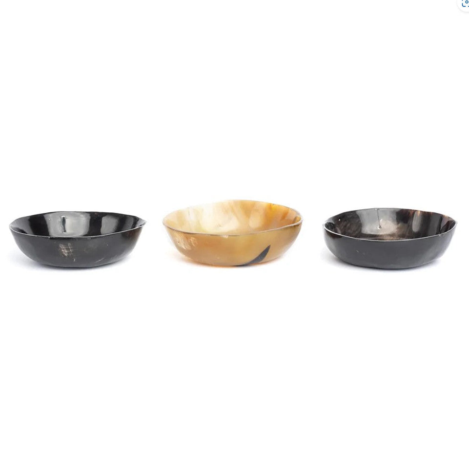 Three horn bowls in black, gold, and silver on a white background
