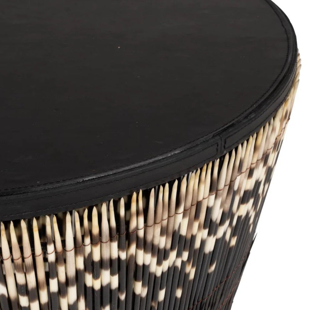 Round side table with black top and patterned base on a white background