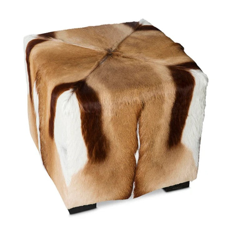 Cube-shaped ottoman with brown and white cowhide pattern on a white background