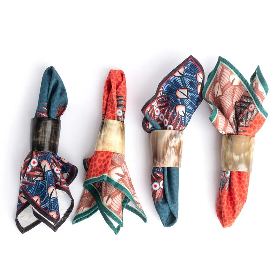 Set of four decorative napkin rings with colorful patterns on a white background