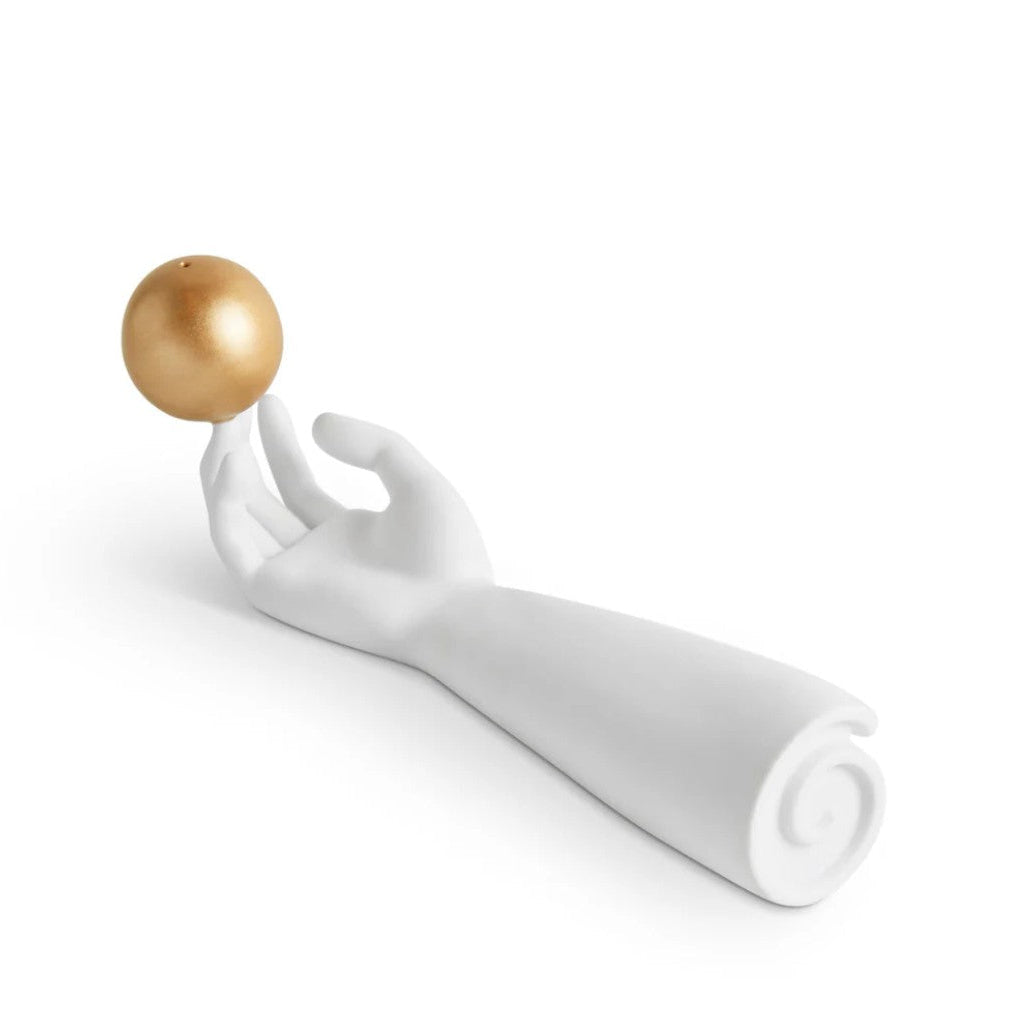 A white sculptural hand and forearm holding a small metallic gold sphere, photographed on a clean white background.