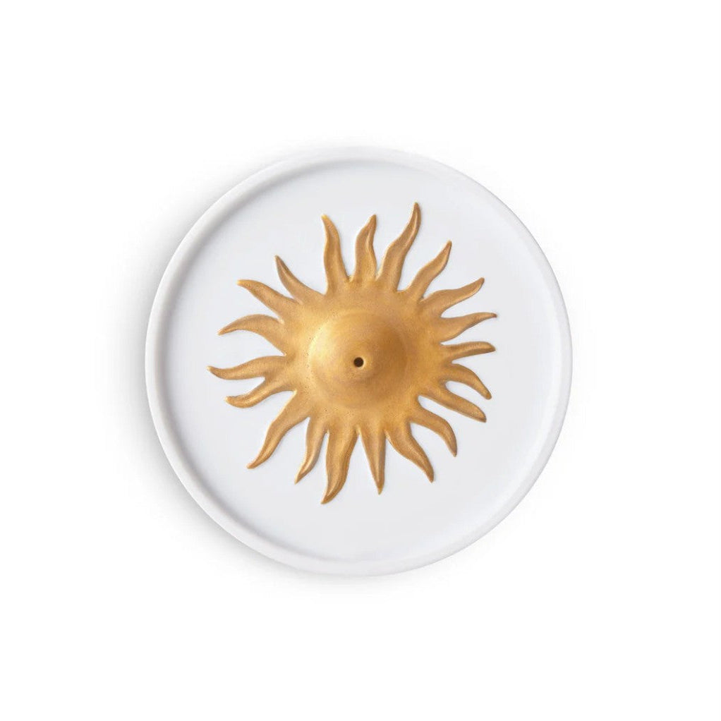 A white round ceramic plate featuring a raised gold-toned sun motif in the center, shown from a top-down view on a white background.