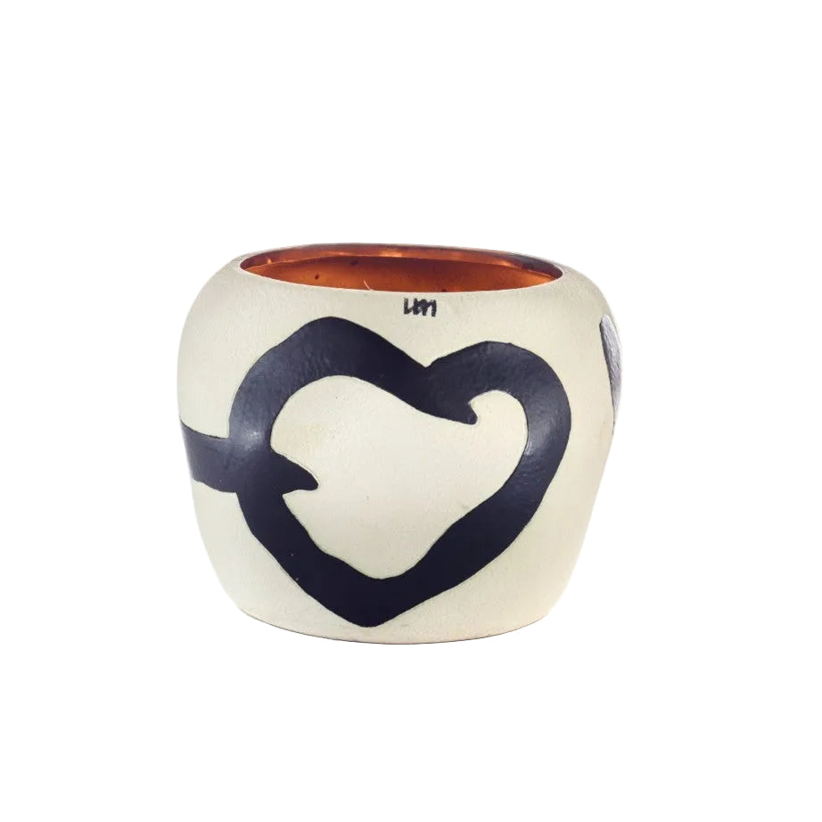 A small ceramic candle holder with a rounded, rounded-rectangle shape, featuring a cream-colored exterior with a bold dark blue heart design and a warm terracotta orange interior, shown on a white background.