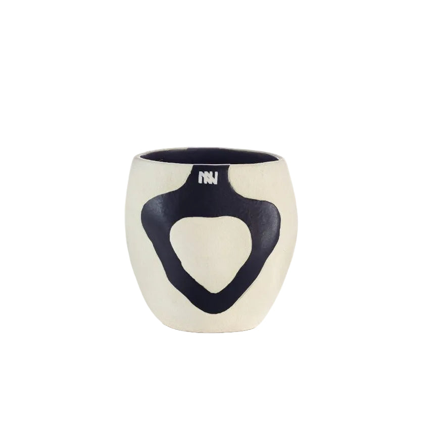 A small ceramic cup with a cream-colored exterior and a dark navy blue interior, featuring a large abstract navy blue shape on the front and the letters 'INI' in white near the rim, shown on a white background.