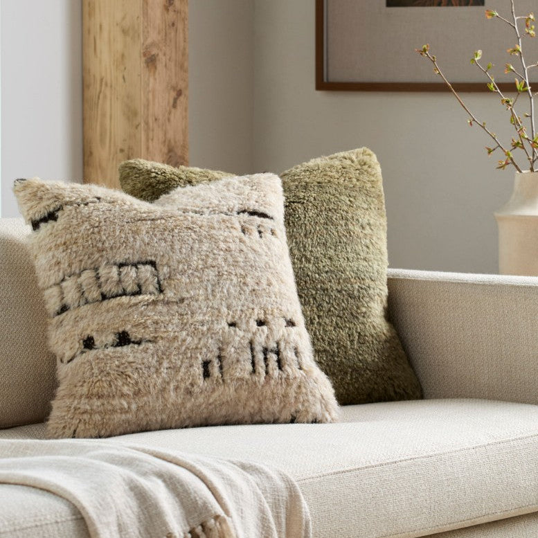 Decorative pillows on a beige sofa with a neutral color scheme.