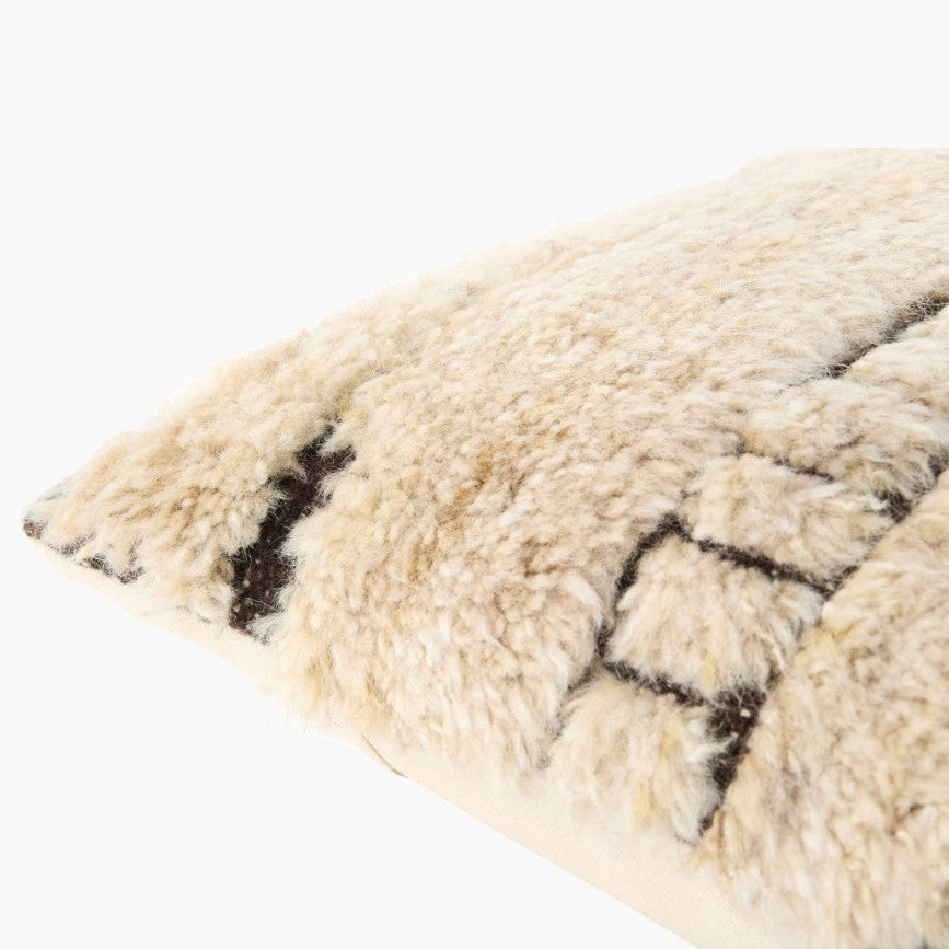 Close-up of a textured beige rug with black patterns on a white background