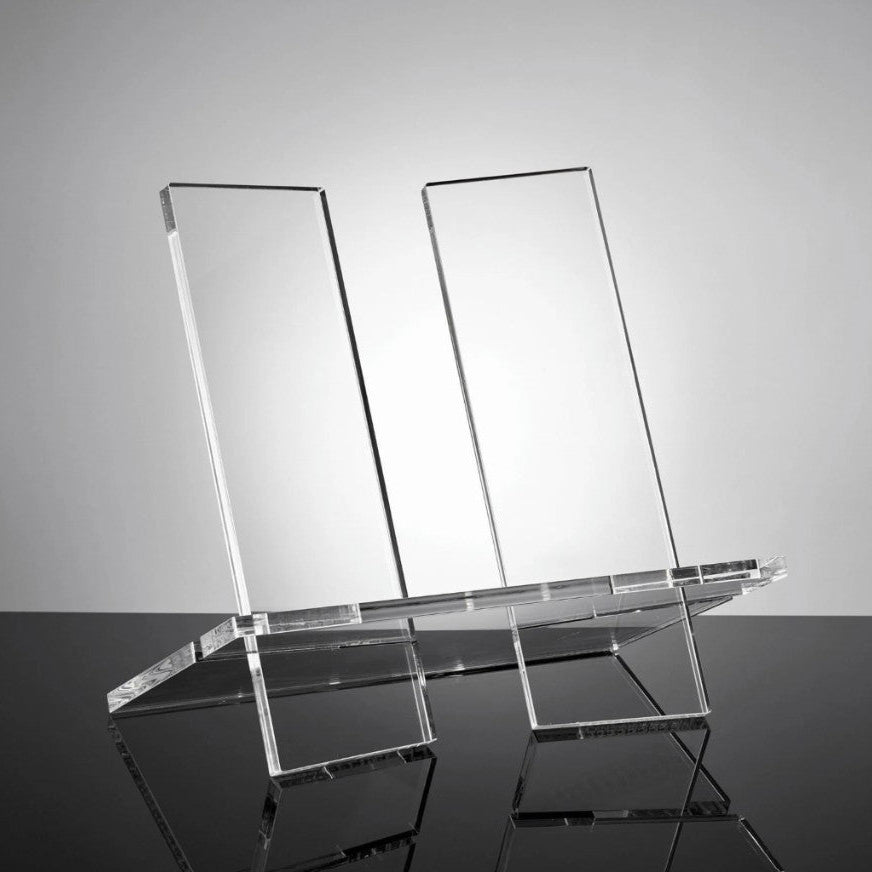 Clear acrylic display stand on a reflective surface with a gray background