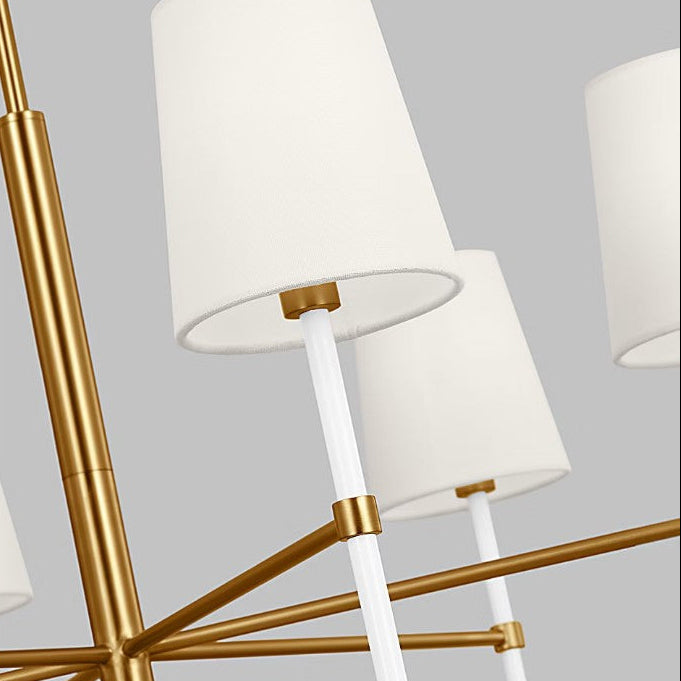 Chandelier with gold arms and white lampshades on a gray background
