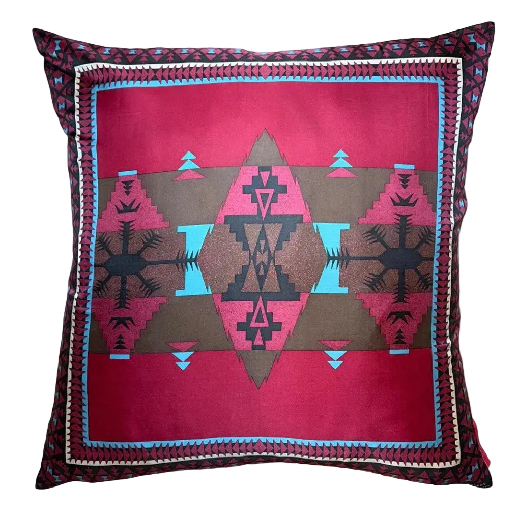 A square throw pillow featuring a Southwestern geometric pattern in vibrant pink, brown, black, and turquoise blue, set against a plain white background.